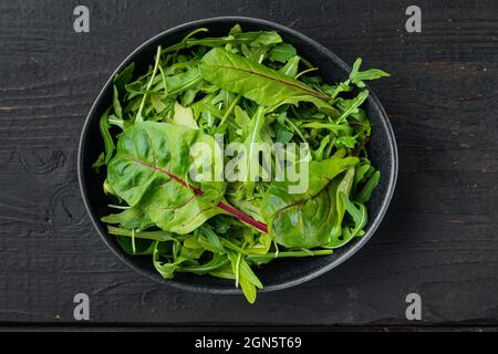Rucola raab e Mangold, garzetta svizzera, su sfondo tavolo in legno nero, vista dall'alto piatto Foto Stock