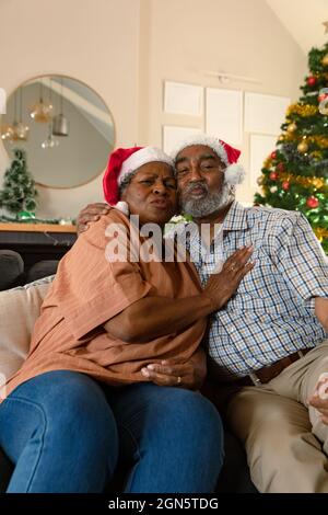 Felice coppia afroamericana che indossa i cappelli di santa che hanno videochiamata al tempo di natale Foto Stock