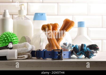 Prodotti da bagno per cani su armadio in legno in un bagno con piastrelle bianche sullo sfondo. Vista frontale. Composizione orizzontale. Foto Stock