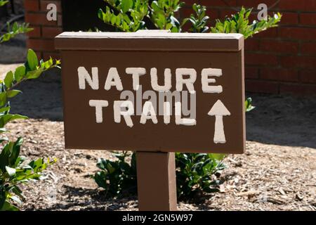 Un segno di sentiero natura in legno indica la strada per il sentiero. Foto Stock