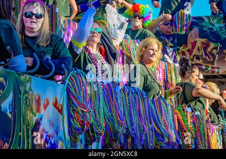 La gente getta le perle da un galleggiante del Mardi Gras durante la parata del Mardi Gras del giorno del Joe Cain, 7 febbraio 2016, a Mobile, Alabama. Foto Stock