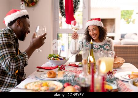 Felice coppia afroamericana che fa brindisi al tavolo di natale Foto Stock