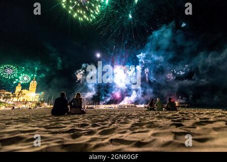 Sitges, Spagna. 22 settembre 2021. Gli spettatori si riuniscono in una spiaggia per seguire la tradizionale esposizione di fuochi d'artificio presso la chiesa 'San Bartolomeu' durante la 'Festa maggiore' di Sitges, 'Santa Tecla'. L'edizione della corona di quest'anno ha assunto una forma molto ridotta lasciando la spiaggia quasi vuota. Credit: Matthias Oesterle/Alamy Live News Foto Stock