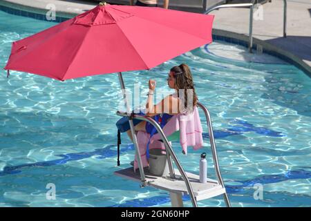 Nevada USA 9-5-21 seduto su una piattaforma e sotto un ombrello il giovane bagnino sta guardando i bagnanti della piscina Beach Club al Flamingo Las Vegas Foto Stock