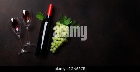 Due bicchieri da vino rosso, bottiglia di vino e uva. Vista dall'alto piatto con spazio per il testo Foto Stock