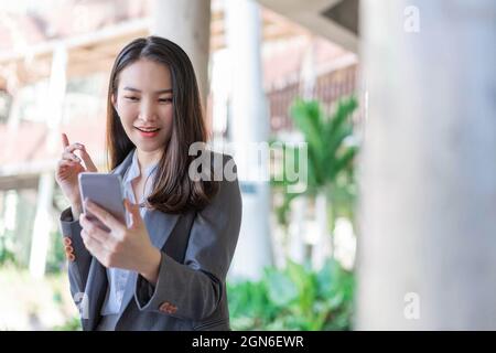 Concetto di donna di lavoro una donna d'affari che ha la videoconferenza con il cliente fuori dell'ufficio. Foto Stock