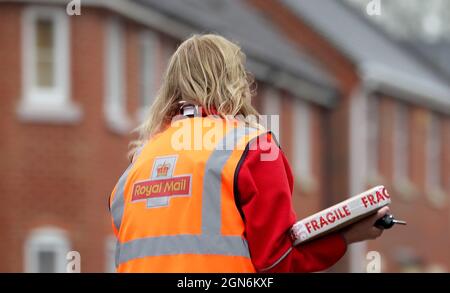 Foto di archivio datata 12/01/21 di Un addetto alla consegna della Royal Mail ad Ashford, Kent. Royal Mail ha messo in guardia per l'aumento dei costi e ha insistito una maggiore domanda di pacchi è qui per rimanere, nonostante un calo delle consegne nel corso dell'estate. Il gruppo ha registrato un calo delle consegne totali di pacchi per volume nei mesi di luglio e agosto, mentre anche i ricavi dei pacchi hanno registrato un lieve calo. Il gruppo ha dichiarato di aspettarsi di vedere "fluttuazioni mensili delle consegne di pacchi" e di essere "sempre più fiduciosi" sul fatto che la tendenza per le consegne di pacchi nel Regno Unito era permanente. Foto Stock