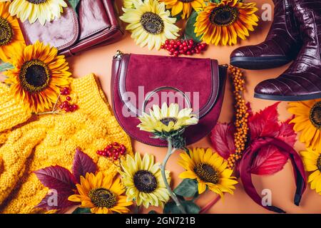 Vista dall'alto della moda femminile autunnale in colore rosso giallo arancio con fiori. Abbigliamento scarpe accessori. Foto Stock
