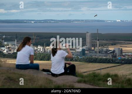 Manchester, Gran Bretagna. 22 settembre 2021. La gente si siede su una collina accanto alla fabbrica di fertilizzanti CF Industries a Cheshire, Gran Bretagna, il 22 settembre 2021. Il segretario britannico all'ambiente George Eustice ha dichiarato mercoledì che l'industria alimentare potrebbe affrontare un brusco aumento dei prezzi del biossido di carbonio (CO2) anche se il governo ha raggiunto un accordo interinale con un importante produttore per riavviare la produzione di CO2. PER ANDARE CON: Industria alimentare del Regno Unito per affrontare il forte aumento del prezzo di CO2: Senior ufficiale Credit: Jon Super/Xinhua/Alamy Live News Foto Stock