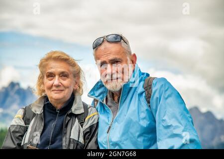 Coppia anziana in pensione che si rilassa nel bel mezzo di un viaggio in montagna Foto Stock