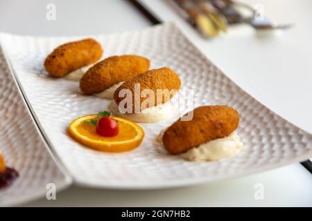 Primo piano delle crocchette su un piatto bianco. Foto Stock