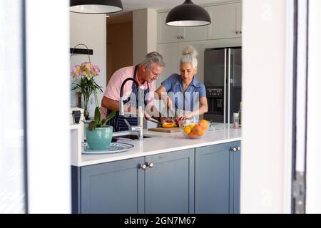 Focalizzato caucasico senior coppia in piedi in cucina e preparare il pasto insieme Foto Stock