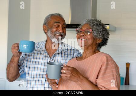 Felice african american Senior Couple tenere tazze con caffè e parlare Foto Stock