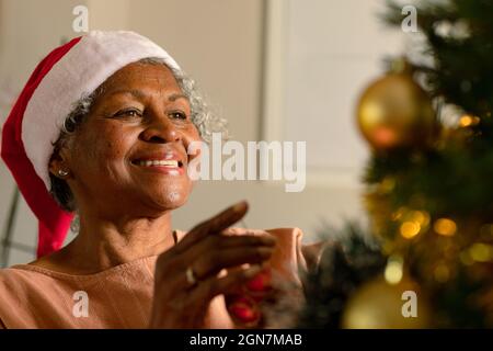 Felice afroamericana anziana donna decorazione albero di natale Foto Stock