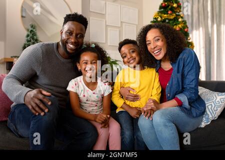 Felice famiglia afroamericana seduto sul divano e guardando la macchina fotografica Foto Stock