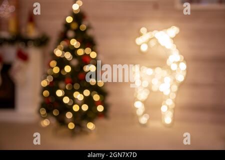 natale sfondo biglietto d'auguri sfocato albero di natale e la figura del cervo da ghirlanda. Foto Stock