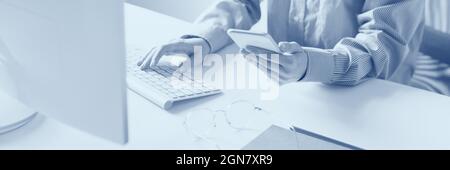 Immagine ritagliata delle mani femminili che lavorano con il computer. Concetto aziendale. Effetto duotono Foto Stock