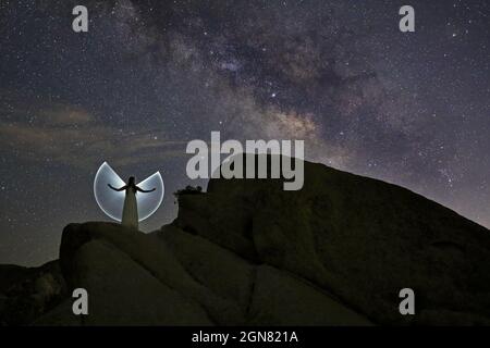 Donna luce dipinta con la notte cielo posa Foto Stock