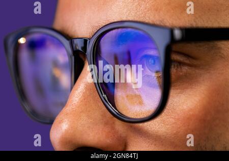 Primo piano di visione focalizzata uomo d'affari lettura, guardare, lavorare in linea, indossa occhiali per computer per ridurre lo sforzo occhio visione offuscata Foto Stock