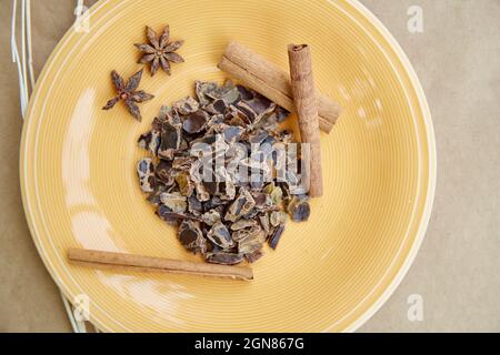 Alternativa a base vegetale - carruba naturale. Antiossidanti organici e proteine. Decorazione con bastoncini di cannella e chiodi di garofano secchi. Vista dall'alto. Foto di alta qualità Foto Stock