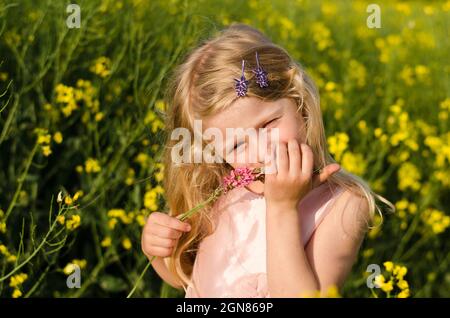 ritratto di bella ragazza bionda in campo di colza Foto Stock