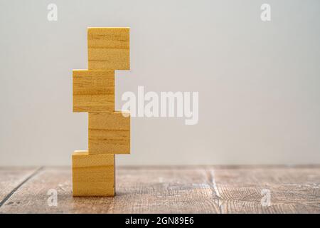 Quattro accatastati cubi quadrati in legno bianco con uno sfondo semplice Foto Stock