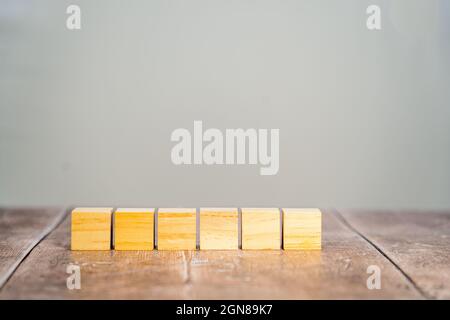 Fila singola di sei mock quadrati in legno bianco cubo con uno sfondo semplice Foto Stock