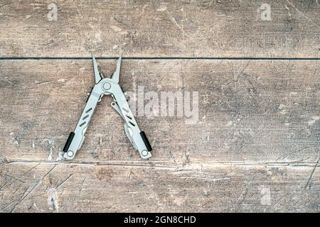 Vecchio acciaio inossidabile utensile multiuso su sfondo di legno piano vista dall'alto posa piana di quercia Foto Stock