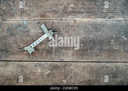 Nuovo set di cacciaviti multiutensile in acciaio inox su sfondo di legno piano vista dall'alto in rovere Foto Stock