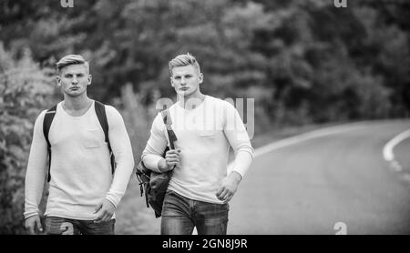 Compagnia amici viaggiatori hitchhiking a sfondo naturale strada. Inizia grande avventura nella tua vita con hitchhiking. Vai vicino alla periferia della città. Viaggiatori Foto Stock