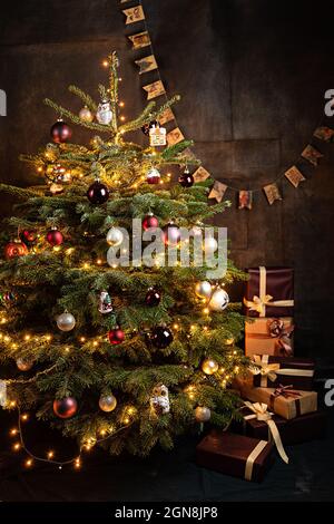 Albero di Natale con decorazioni, vecchi giocattoli e libri d'epoca, mucchi di regali, concetto di cartolina Foto Stock