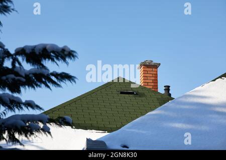 Chimnies su una casa con neve Foto Stock