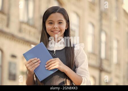 Espandi il tuo cervello leggendo. Happy bambino tenere libro all'aperto. Biblioteca della scuola. Lettura abitudine. Home Reading. Bambini immaginazione e fantasia. Formale e. Foto Stock