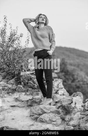 Donna caldo maglione natura sfondo sfocato. Concetto di eleganza. Ragazza fantasia trucco viso indossare maglione a maglia. Lo stile è tutto l'equilibrio. Stupendo Foto Stock