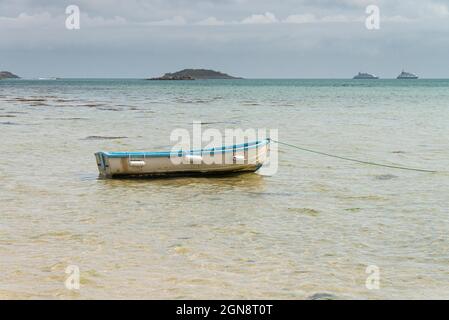 Una piccola barca blu e bianca al largo della costa di St Martin's, Isole di Scilly Foto Stock