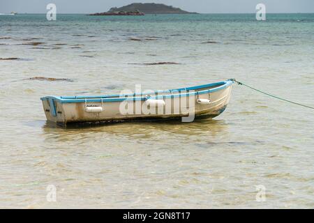 Una piccola barca blu e bianca al largo della costa di St Martin's, Isole di Scilly Foto Stock