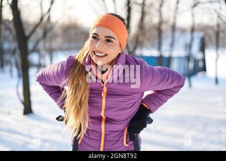 Donna sorridente in abiti caldi durante l'inverno Foto Stock
