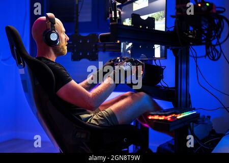 Videogamer maschio che indossa le cuffie mentre gioca a un videogioco in studio Foto Stock