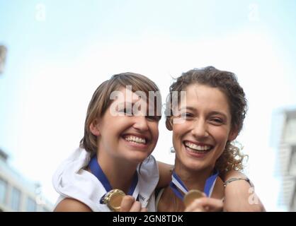 Felice atlete femminile indossare medaglie Foto Stock