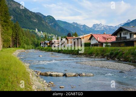 Germania, Baviera, Oberstdorf, fiume Trettach che scorre oltre città di montagna in estate Foto Stock