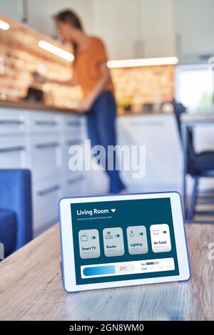 Tablet digitale con applicazione per la casa intelligente sul tavolo della casa Foto Stock