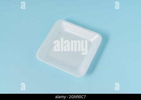 Contenitore in polistirene su sfondo blu chiaro. Foto Stock
