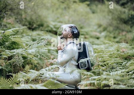 Ambientalista maschile con tuta protettiva che si schiaccano nella foresta Foto Stock