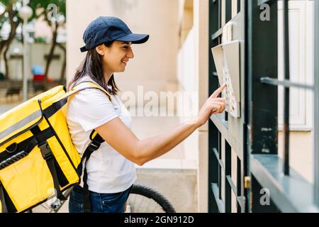 Donna sorridente con porta di apertura zaino Foto Stock