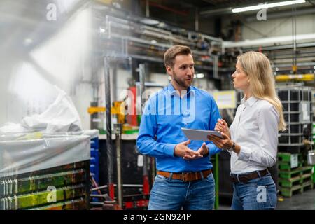 Professionisti aziendali con tablet digitale che hanno discusso nel settore Foto Stock