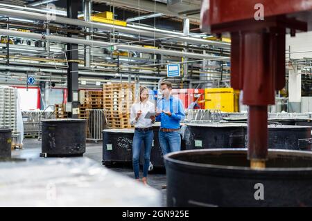 Professionisti aziendali che hanno discusso dei tablet digitali nel settore delle vernici Foto Stock