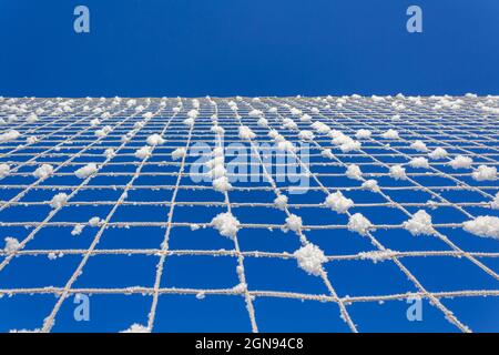 Rete da pallavolo coperta di neve. Minimalismo della natura. Foto Stock