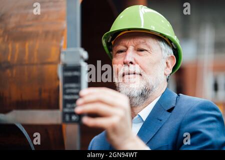 Uomo d'affari che discute con il collega mentre lavora in magazzino Foto Stock