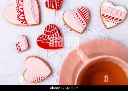 Shot studio di ciotola di miele, cucchiaia da miele, fragole e mini torte a forma di cuore appena sfornate Foto Stock