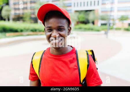 Uomo giovane e sorridente che indossa lo zaino Foto Stock